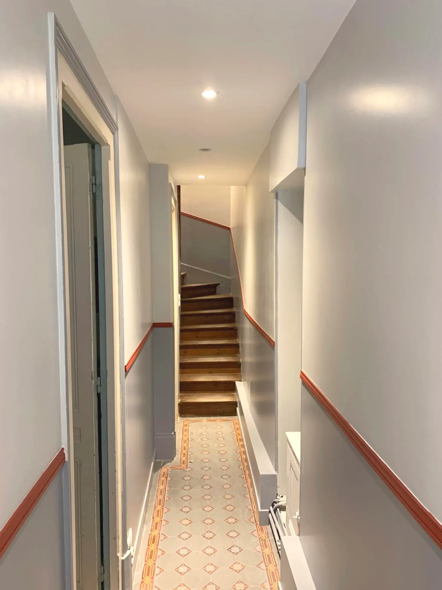 Couloir rénové, sol en carreaux de ciment et escalier en bois