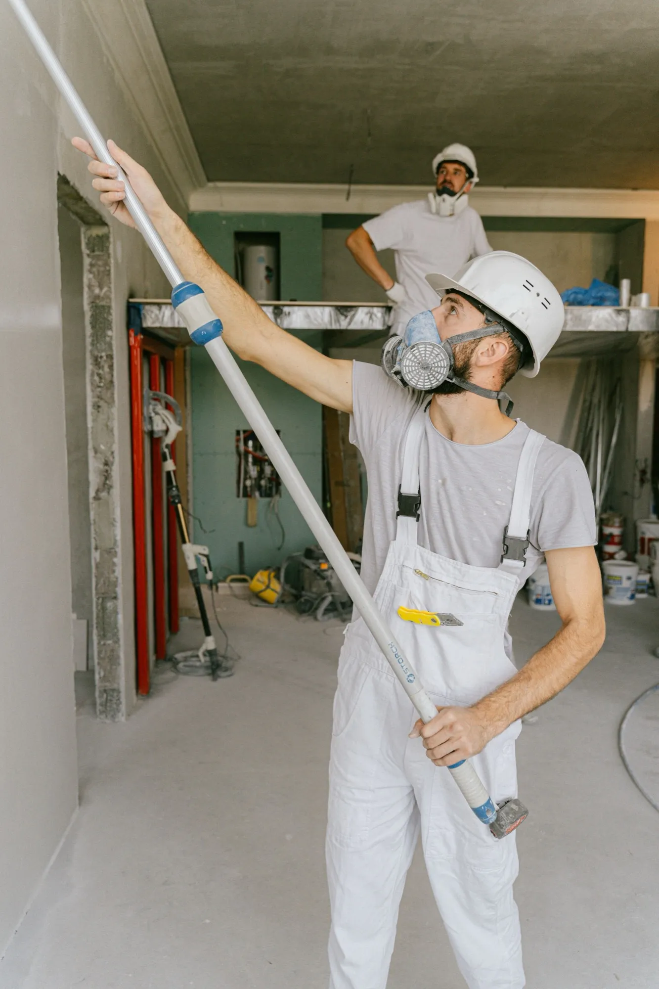 Deux artisans casqués en intervention sur un chantier de rénovation