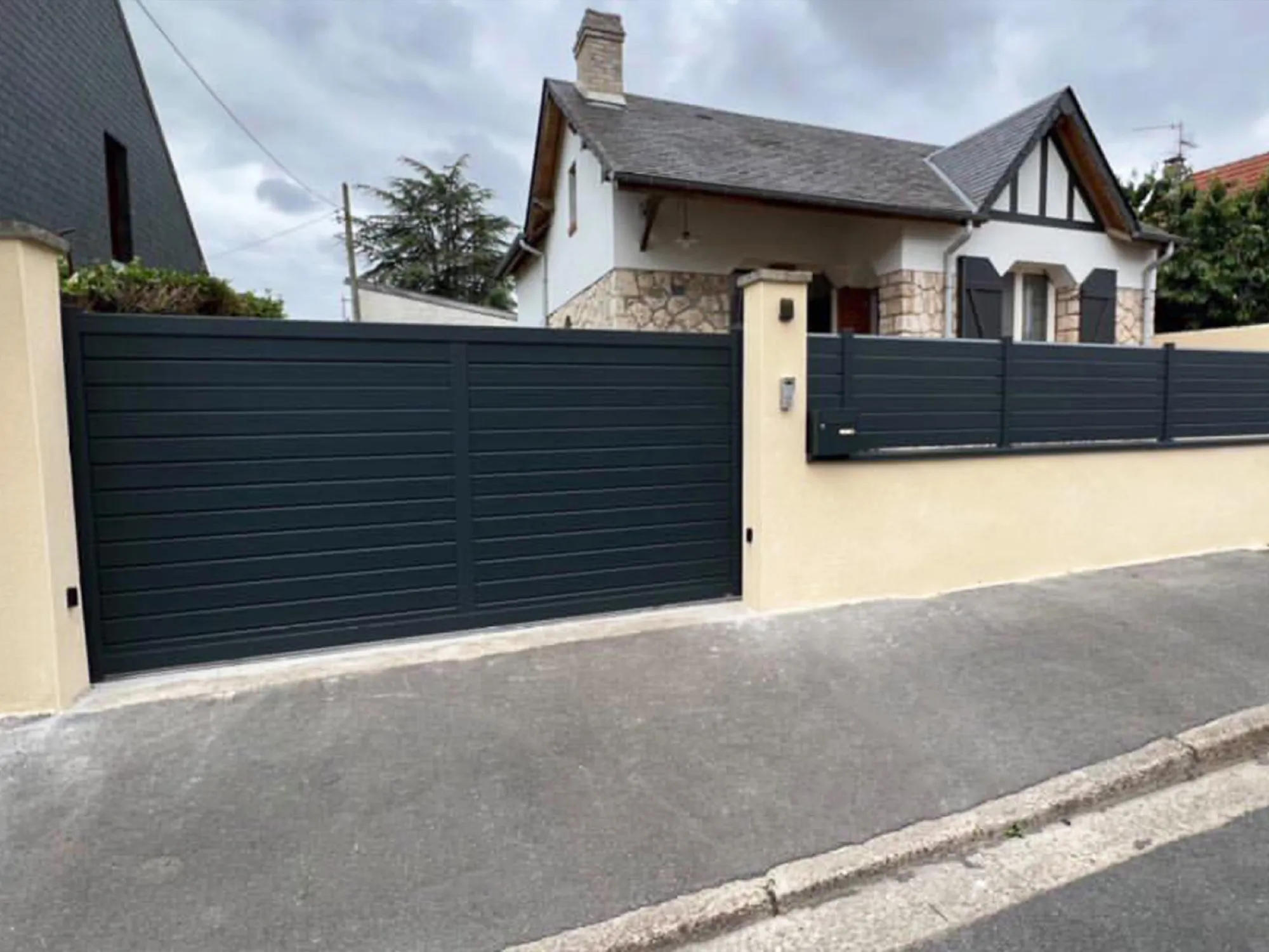 Portail coulissant et clôture anthracite sur muret enduit