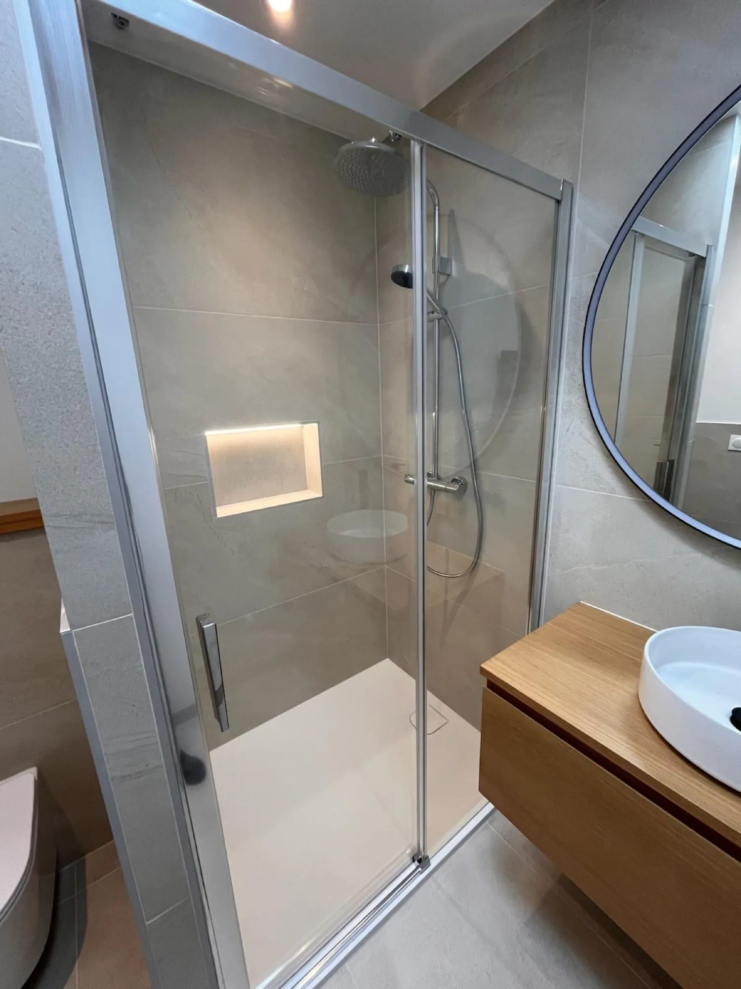 Douche vitrée avec niche éclairée et meuble vasque en bois
