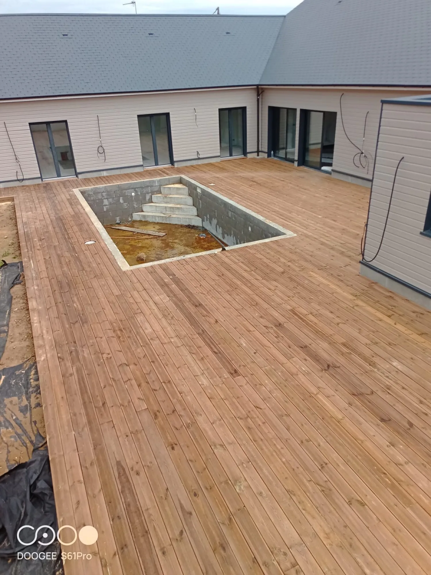 Grande terrasse en bois posée autour d’une piscine